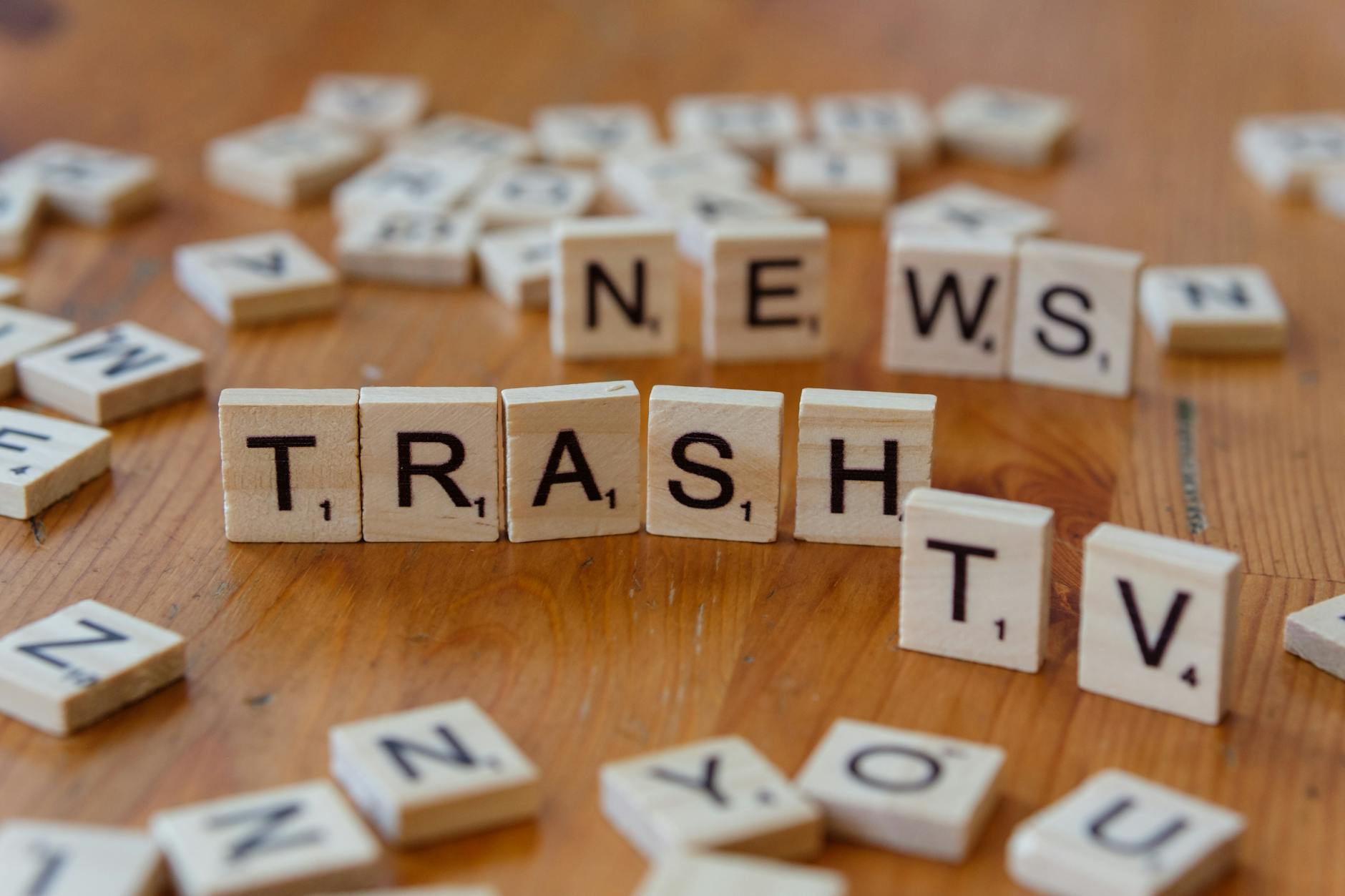 Drewniane płytki z literami układające się w napis Trash TV News