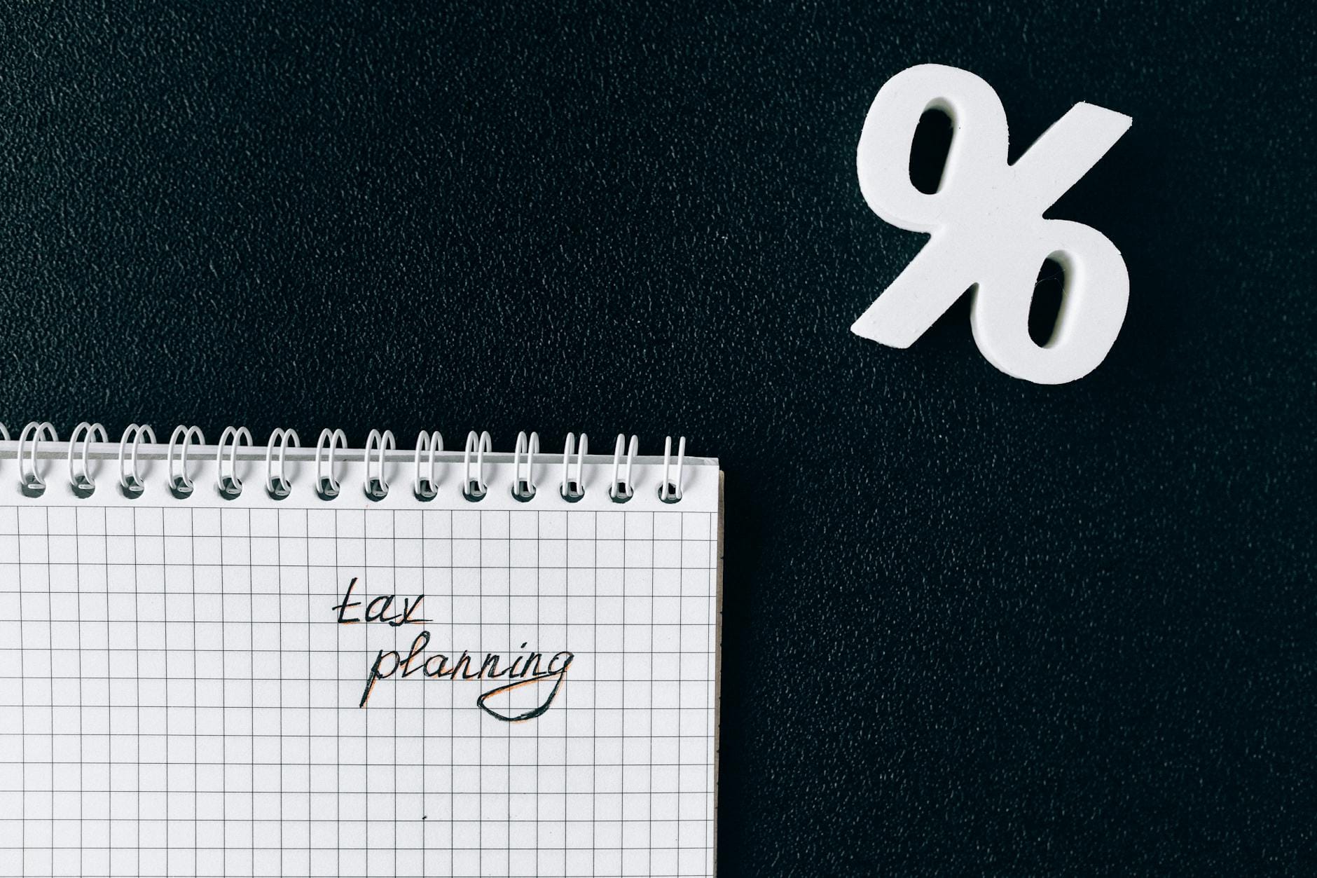 Notes z napisem tax planning i symbolem procenta na czarnym tle