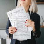 Dlaczego NIP firmy zmienia się po przekształceniu i jak to sprawdzić Bizneswoman w biurze analizuje dokumenty podatkowe firmy