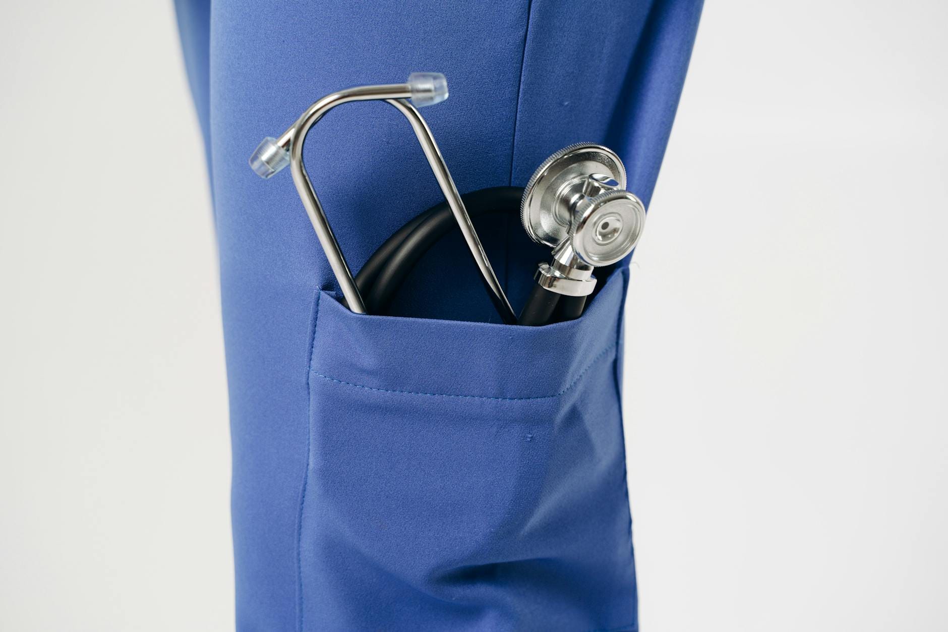 Stetoskop w niebieskiej kieszonce fartucha medycznego
