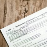 VIES nie potwierdza VAT UE, ale kontrahent ma faktury: co weryfikować dodatkowo Zbliżenie formularza podatkowego VAT UE na drewnianym biurku