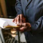 Jak zweryfikować beneficjenta rzeczywistego, gdy KRS nie daje pełnego obrazu? Biznesmen w garniturze analizuje dokument przy biurku indoors