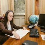 Pełnomocnictwo w KRS: jak je zweryfikować i nie dać się oszukać Bizneswoman analizuje dokumenty prawne przy biurku w nowoczesnym biurze