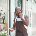 Czy da się ustalić właściciela spółki z o.o. po adresie? Legalne źródła i ograniczenia Mężczyzna w fartuchu rozmawia przez telefon przed sklepem firmowym