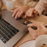 Płacenie kartą przez internet na laptopie z bliskiej perspektywy