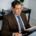 Jak interpretować daty wpisów w KRS i CEIDG, by nie pomylić stanu aktualnego Prawnik w garniturze analizuje dokumenty w biurze