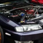 Zbliżenie tuningowanego fioletowego silnika z pomarańczowymi felgami