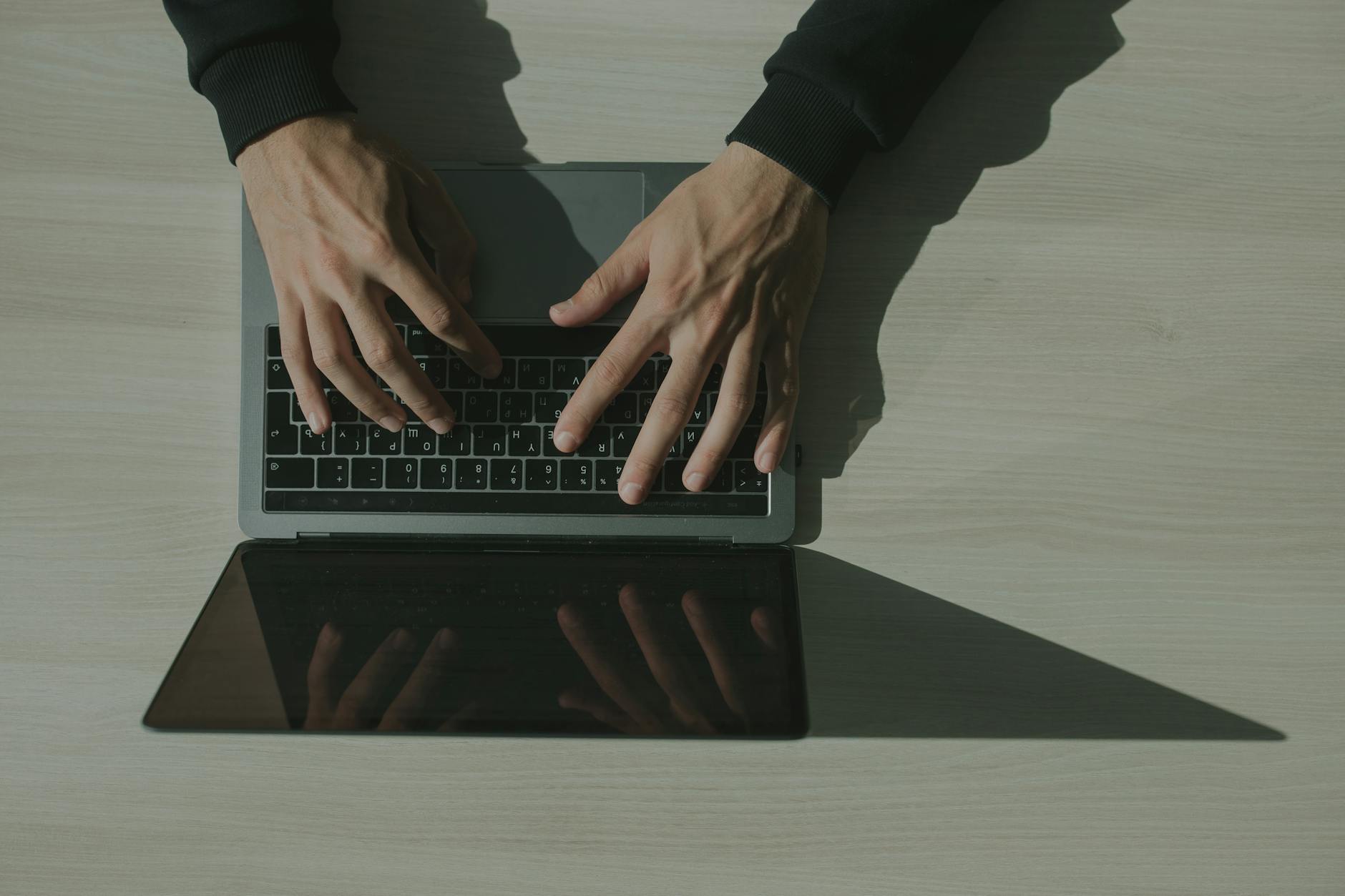 Dłonie piszące mail na laptopie podczas weryfikacji nadawcy
