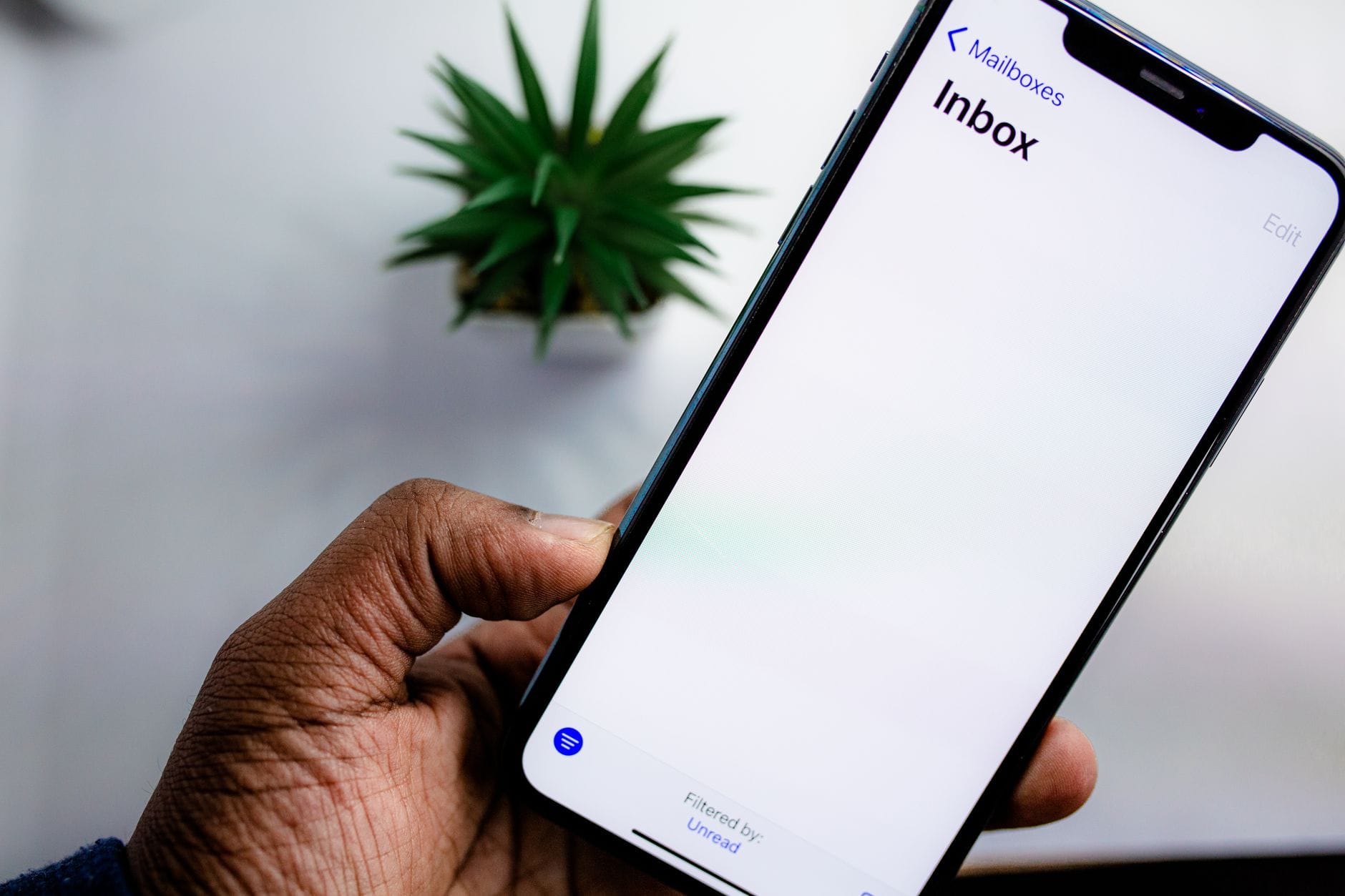 Dłoń trzymająca smartfon z widokiem skrzynki mailowej