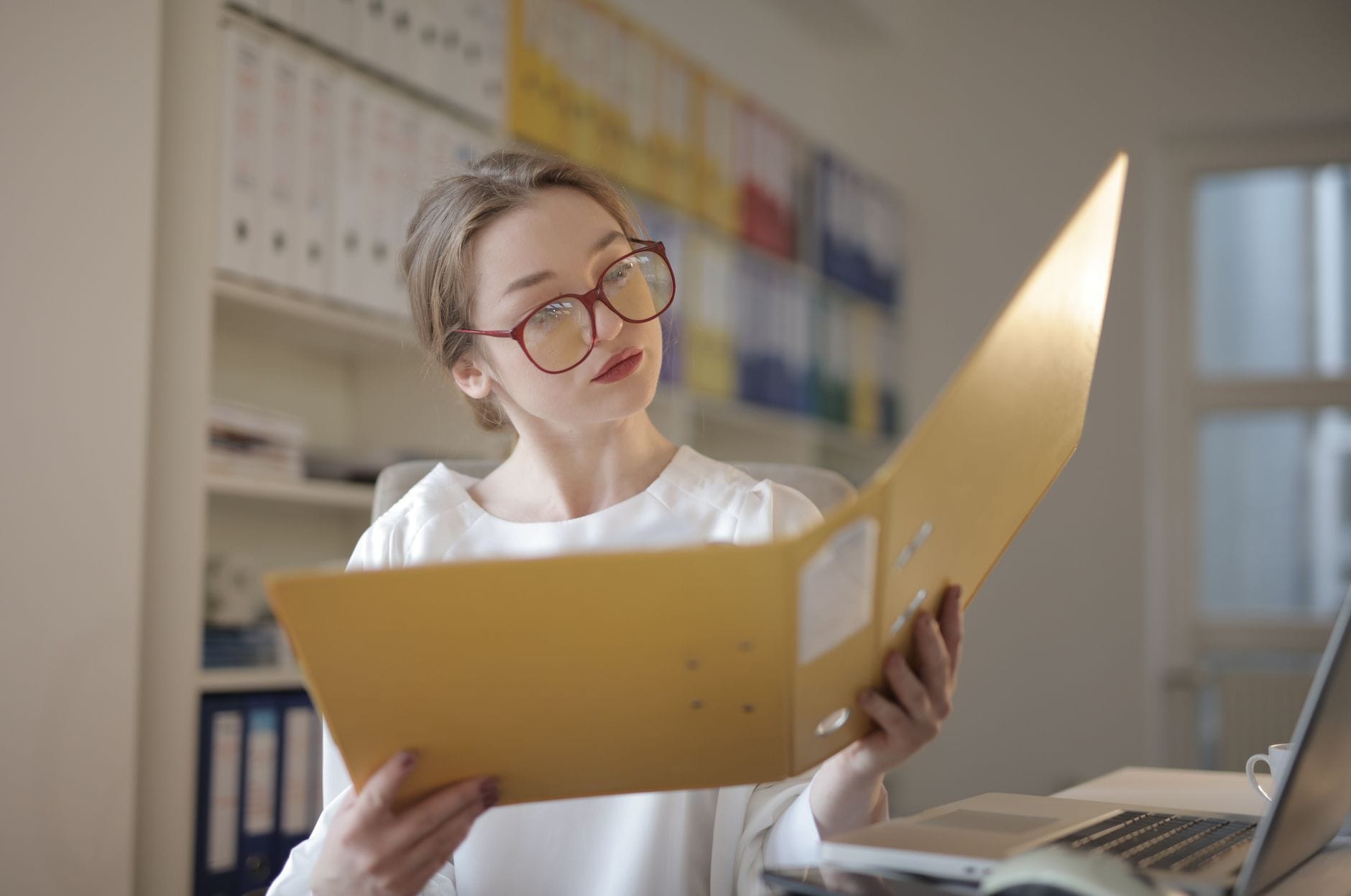 Kobieta w biurze uważnie analizuje dokumenty związane z opiniami klientów