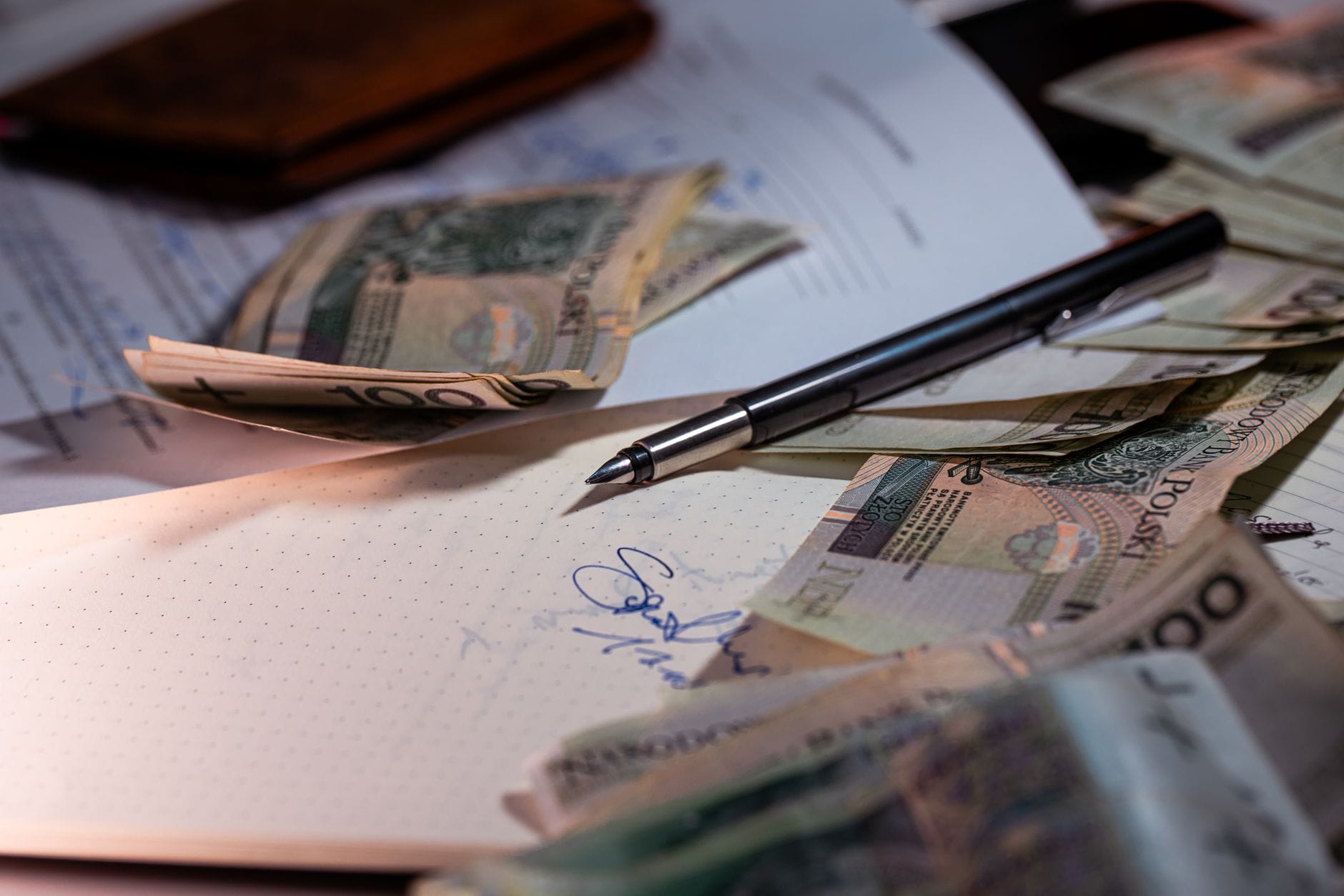 Polskie banknoty, dokumenty i długopis na biurku podczas analizy finansowej