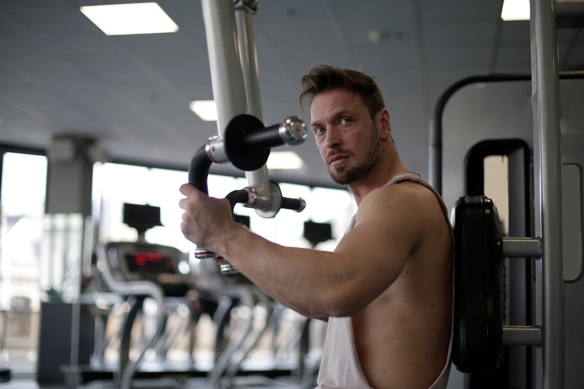 Skupiony mężczyzna trenuje biceps na siłowni w Koziegłowach