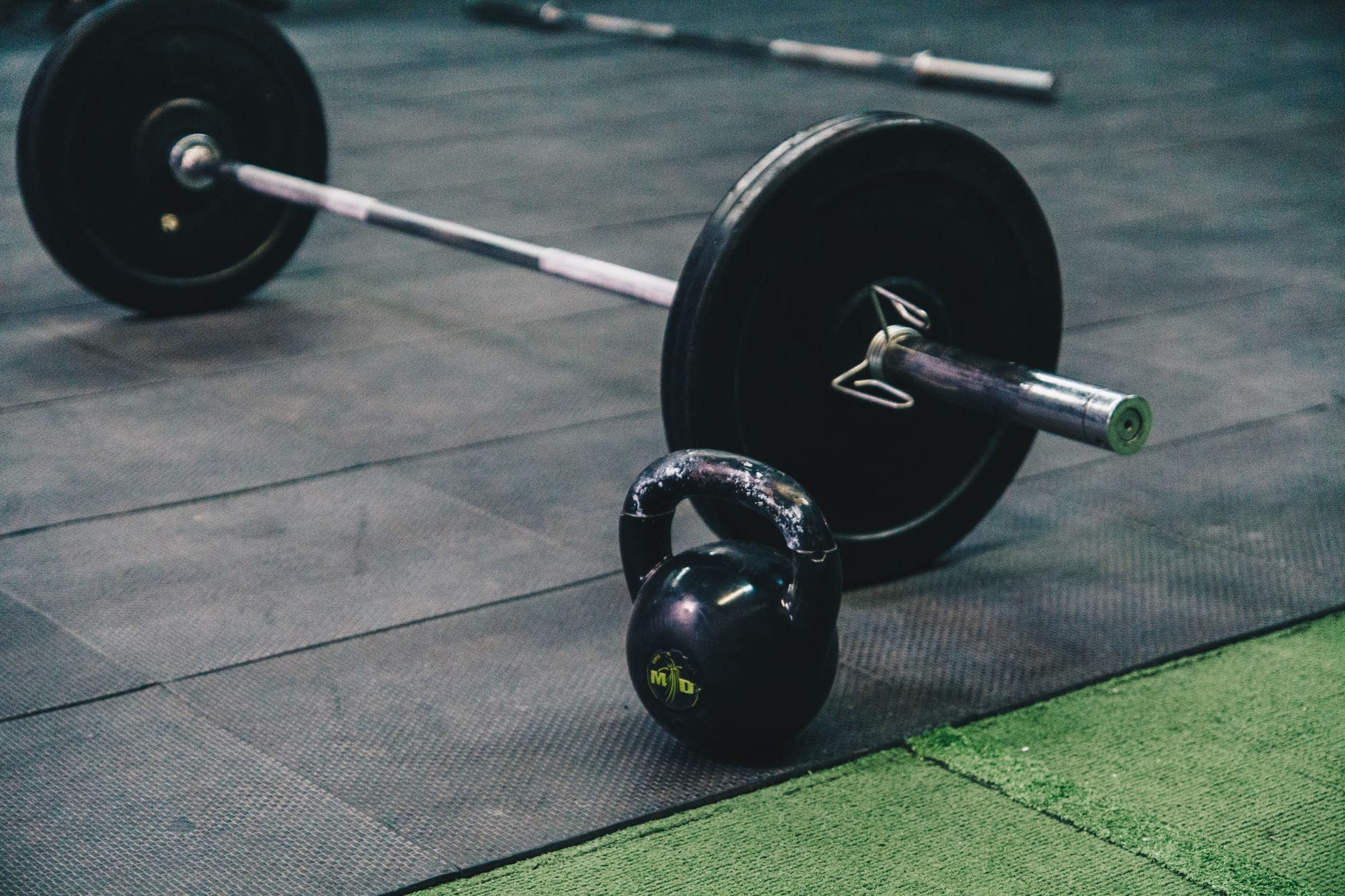 Sztanga i kettlebell leżące na podłodze siłowni w Koziegłowach