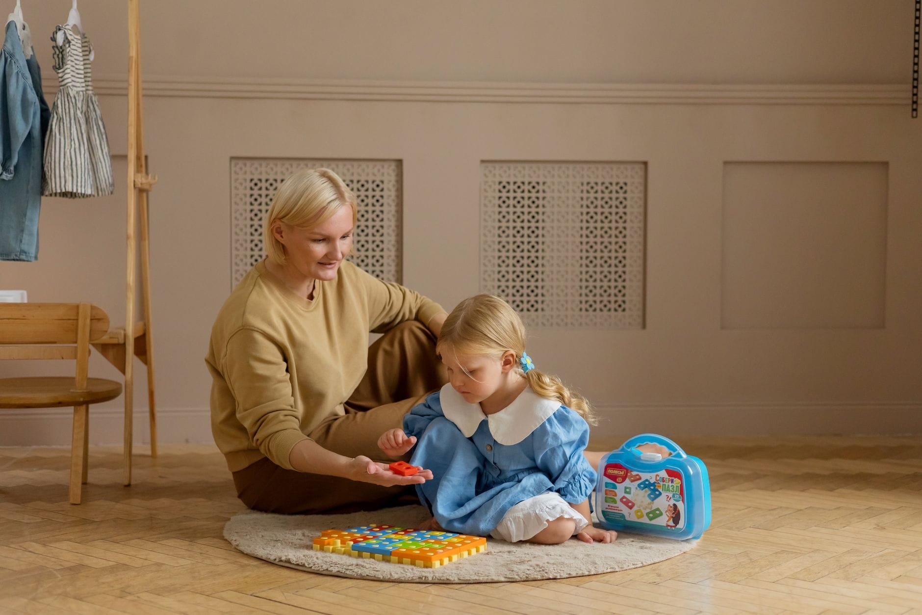 Mama bawiąca się z córką edukacyjnymi zabawkami w domu