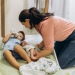 Jak wspierać dziecko w adaptacji do przedszkola i budować jego poczucie bezpieczeństwa Mama opiekuje się dziećmi w spokojnym, przytulnym pokoju przedszkolnym