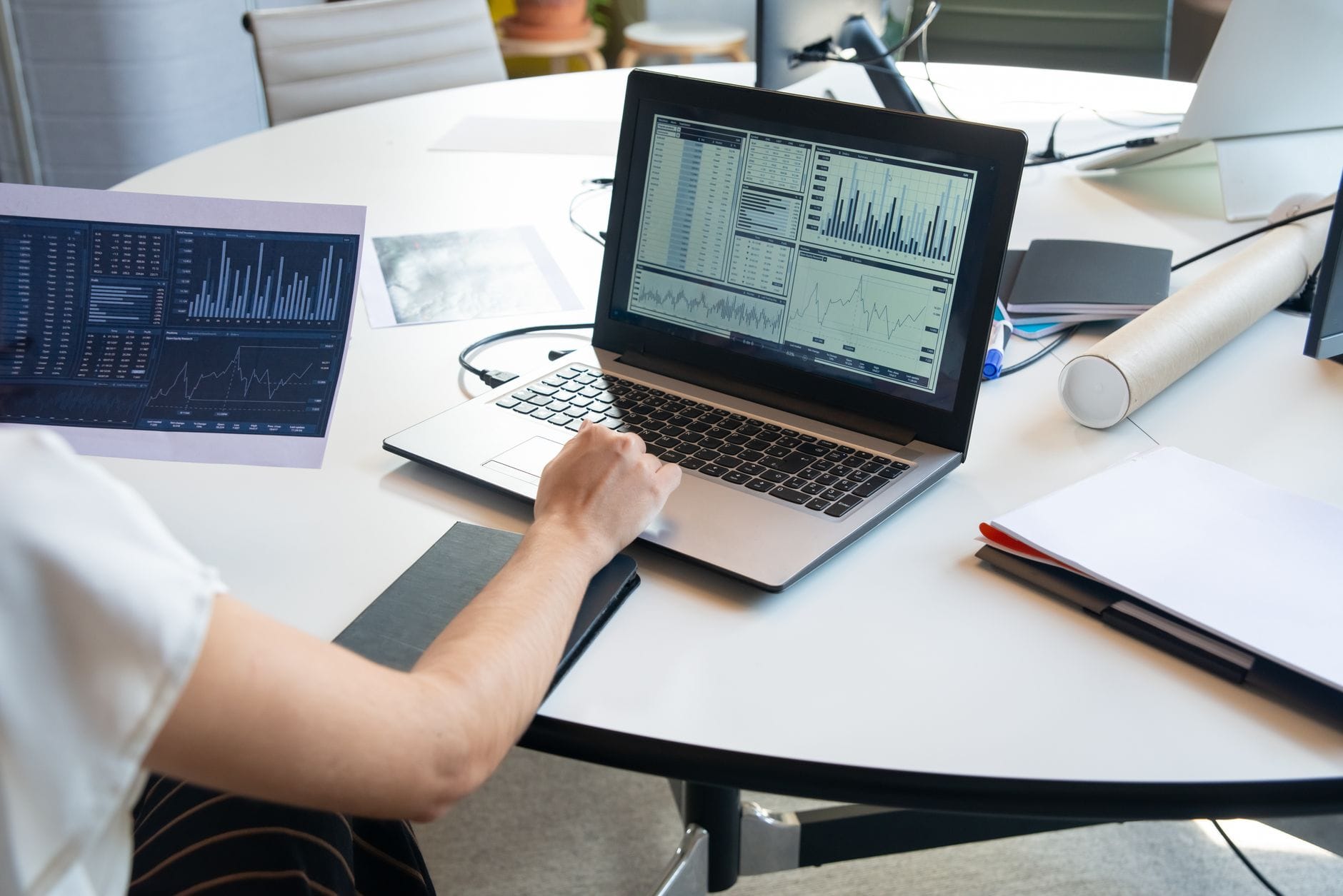 Przedsiębiorca analizuje wykresy finansowe CEIDG na laptopie w biurze