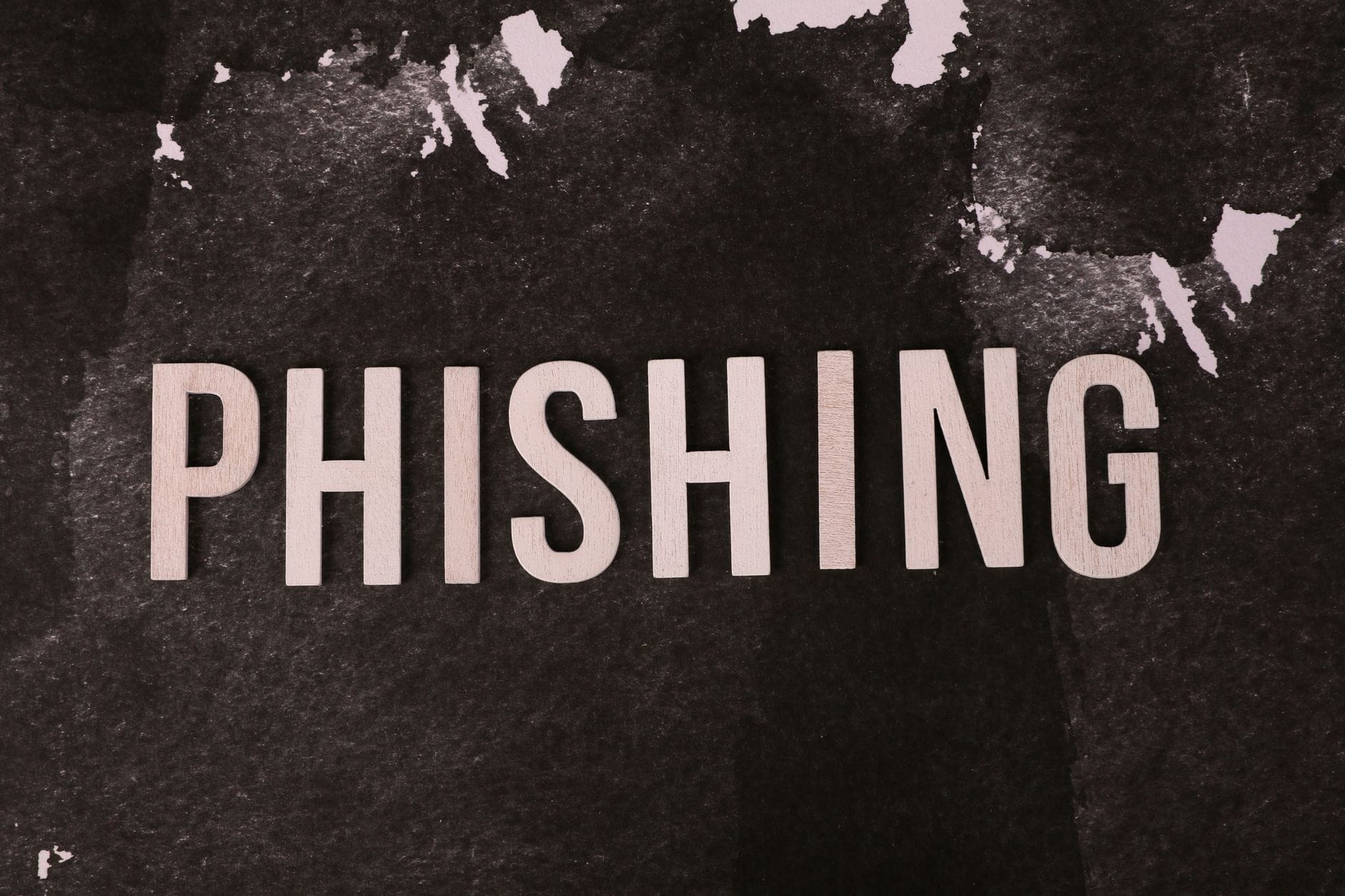 Napis phishing na ciemnym, teksturowanym tle